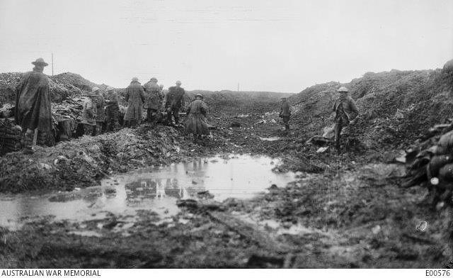 Soldiers make their way through the muddy Somme landscape. AWM E00576